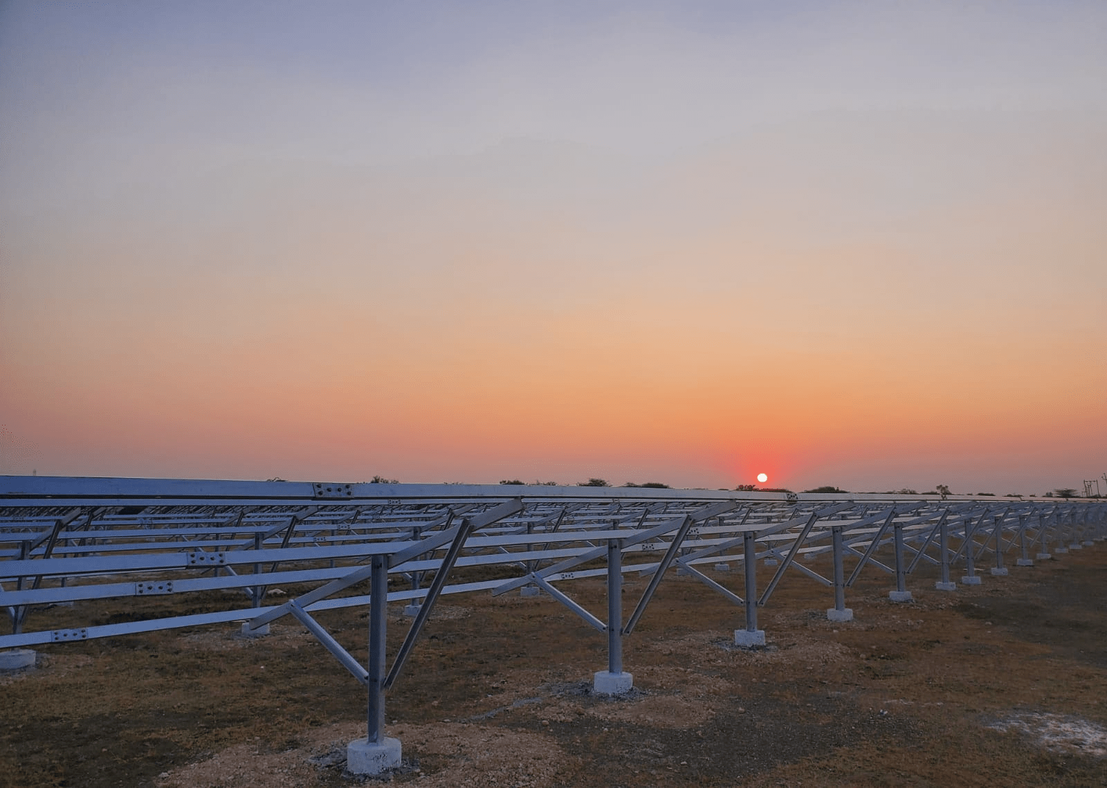 Professional ground mounted solar structure installation at sunset