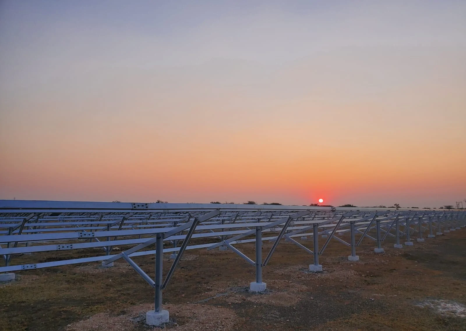 Professional ground mounted solar structure installation at sunset
